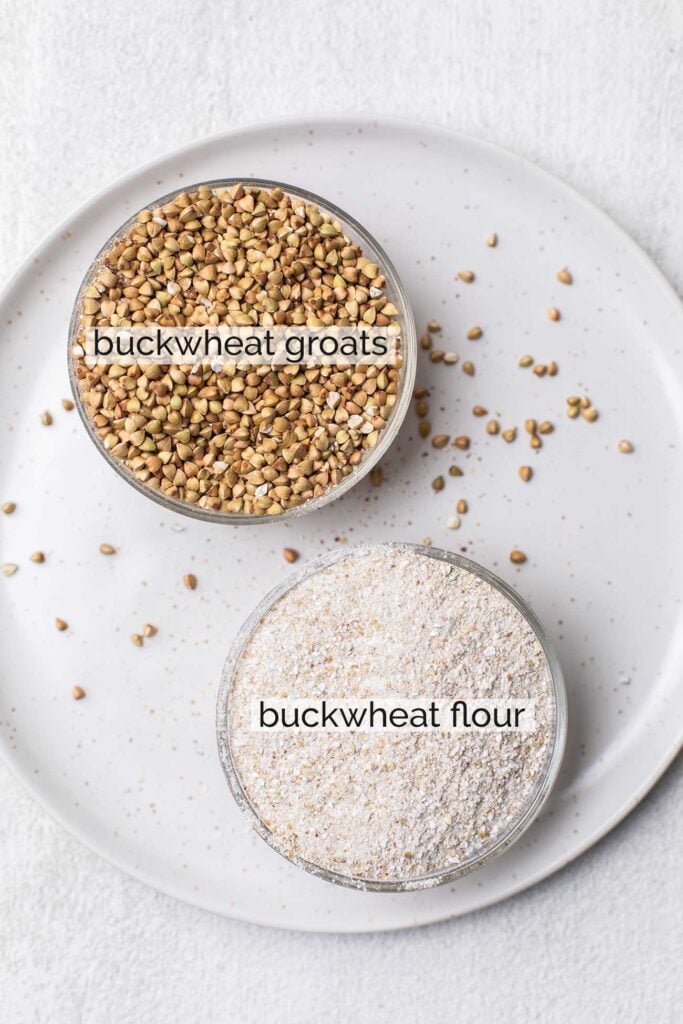 A cup of buckwheat groats shown next to a cup of buckwheat flour.