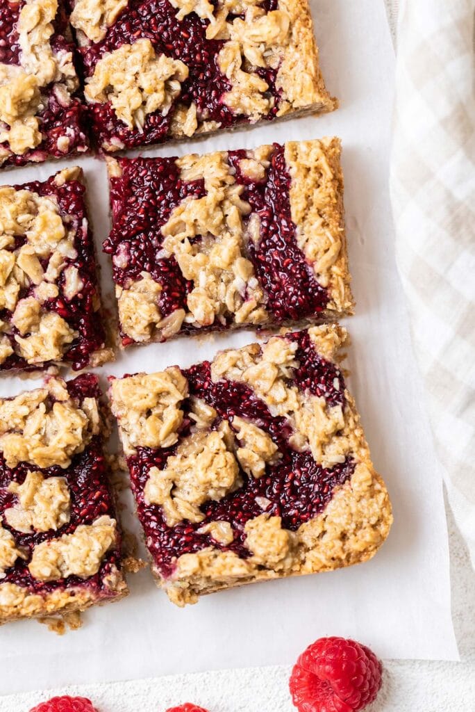 Baked raspberry bars with a golden brown edge.