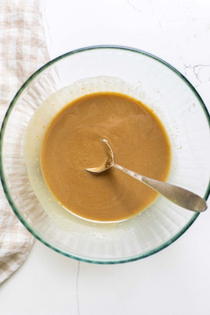 Sunflower seed butter, maple syrup, and coconut oil combined in a large bowl.
