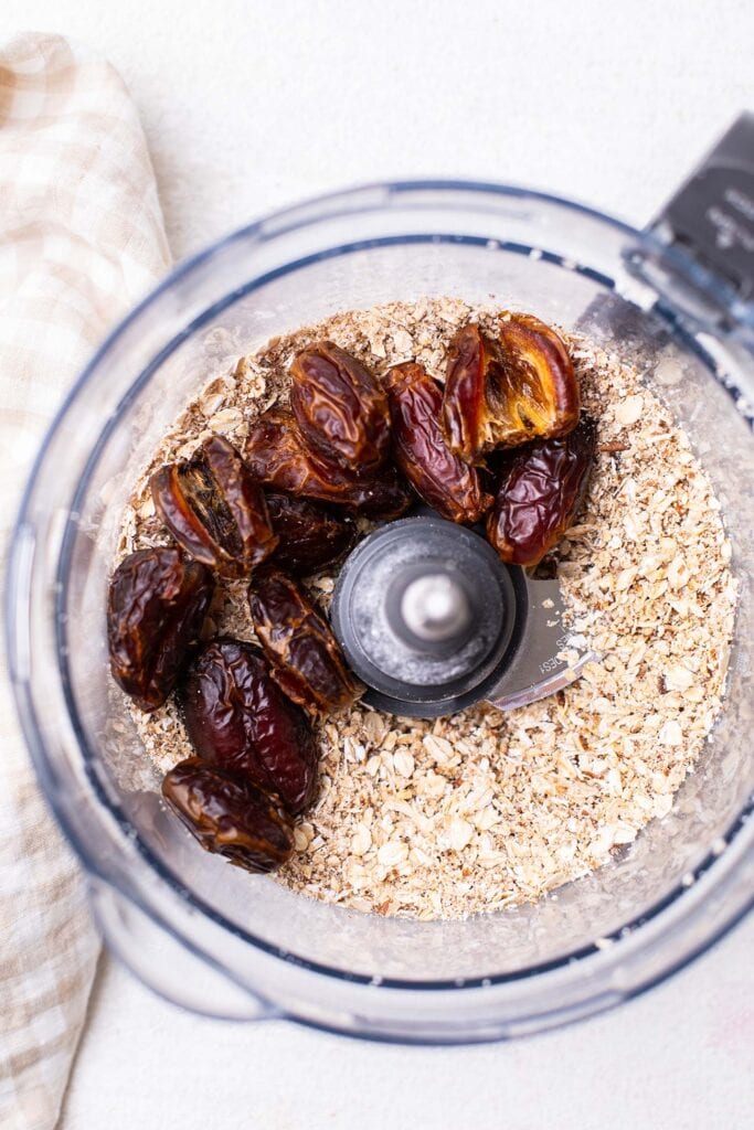 Dates added to a food processor along with an oat and pecan flour.