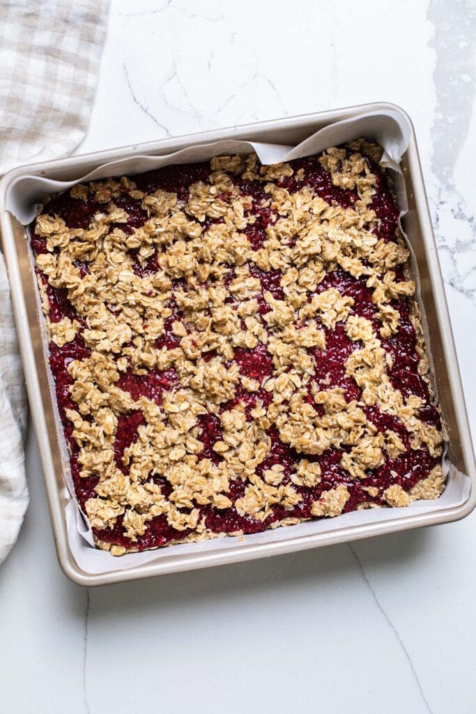 Raspberry bars topped with a crumble topping.