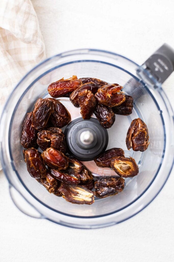 Dates added to a food processor bowl.