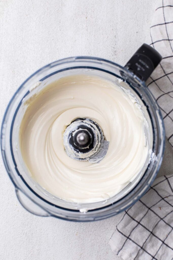 Cream cheese softened in a food processor bowl.