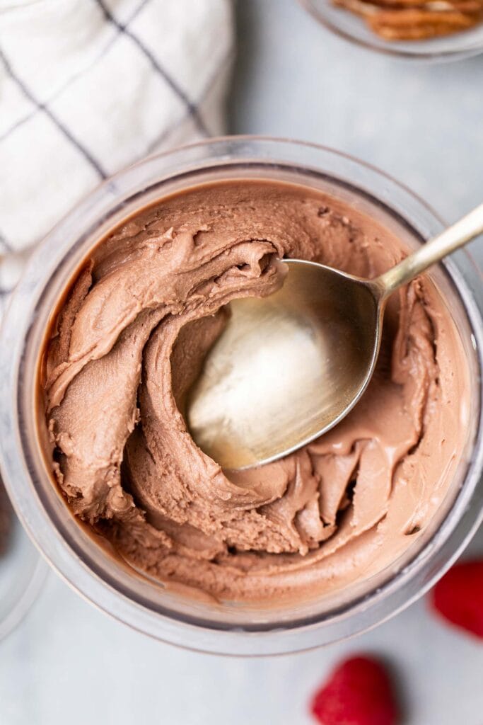 A gold spoon digging in to a thick chocolate protein ice cream.