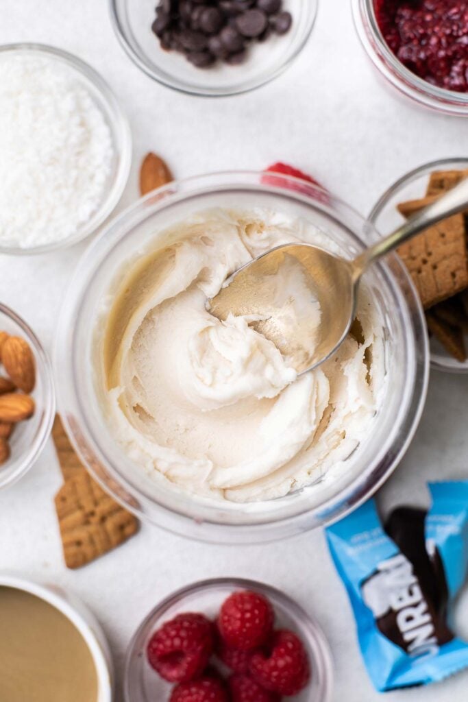 A pint of Ninja Creami protein ice cream shown with toppings and mix in suggestions.