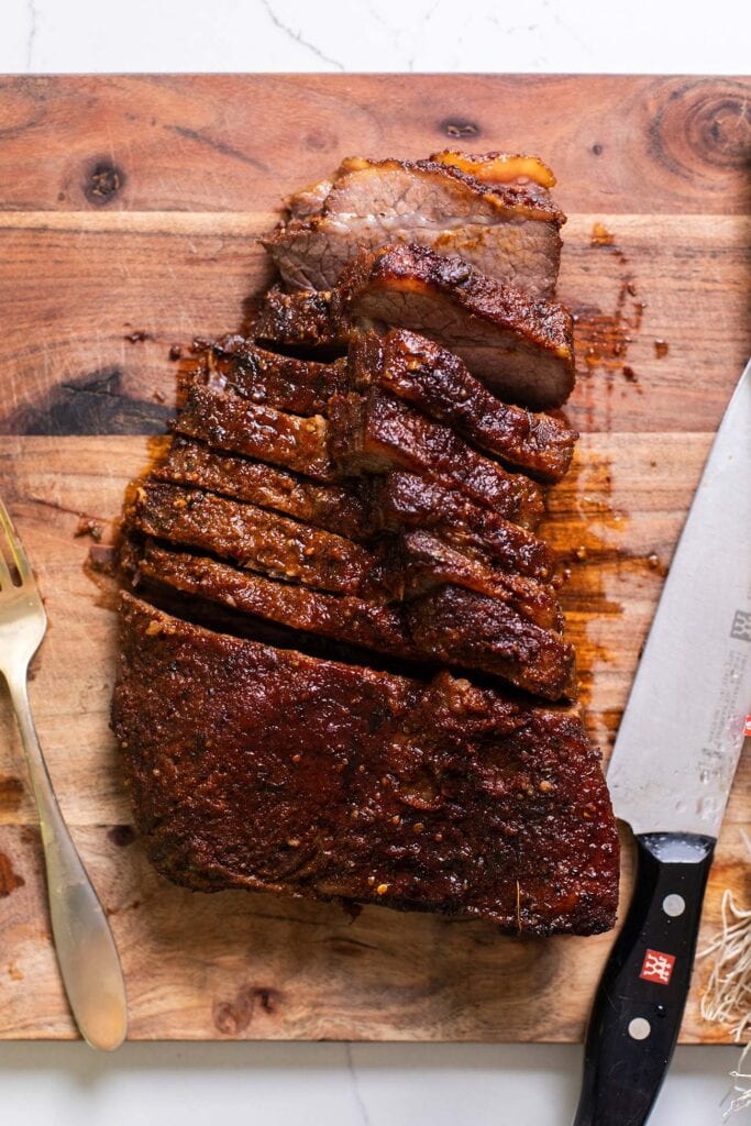 A brisket being cut across the grain.