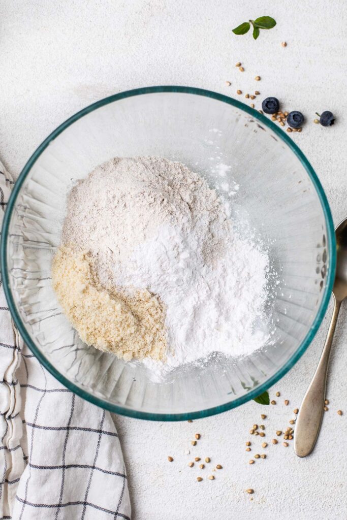 A mixture of flours shown in a bowl being mixed together.