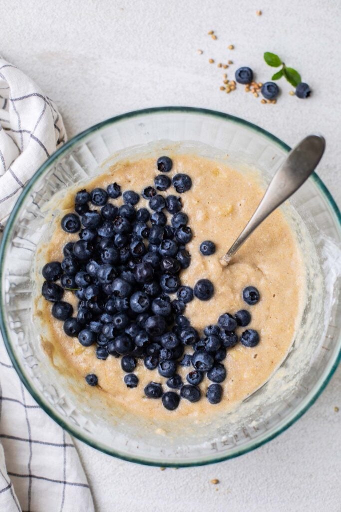 Folding blueberries into the buckwheat muffin batter.