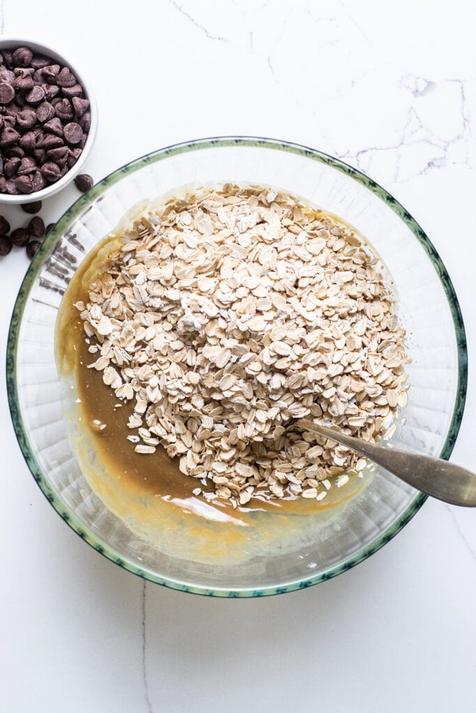 Oatmeal and sea salt added to the bowl with the wet mixture.