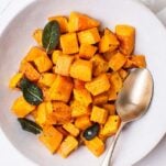 A bowl of air fryer butternut squash garnished with crispy sage.