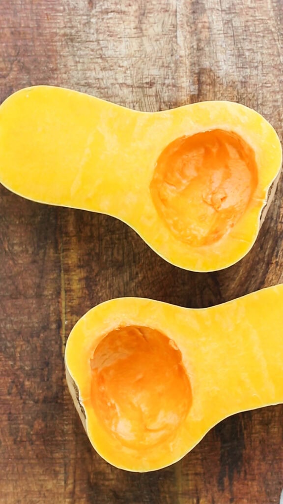 A butternut squash cut in half with the seeds removed.