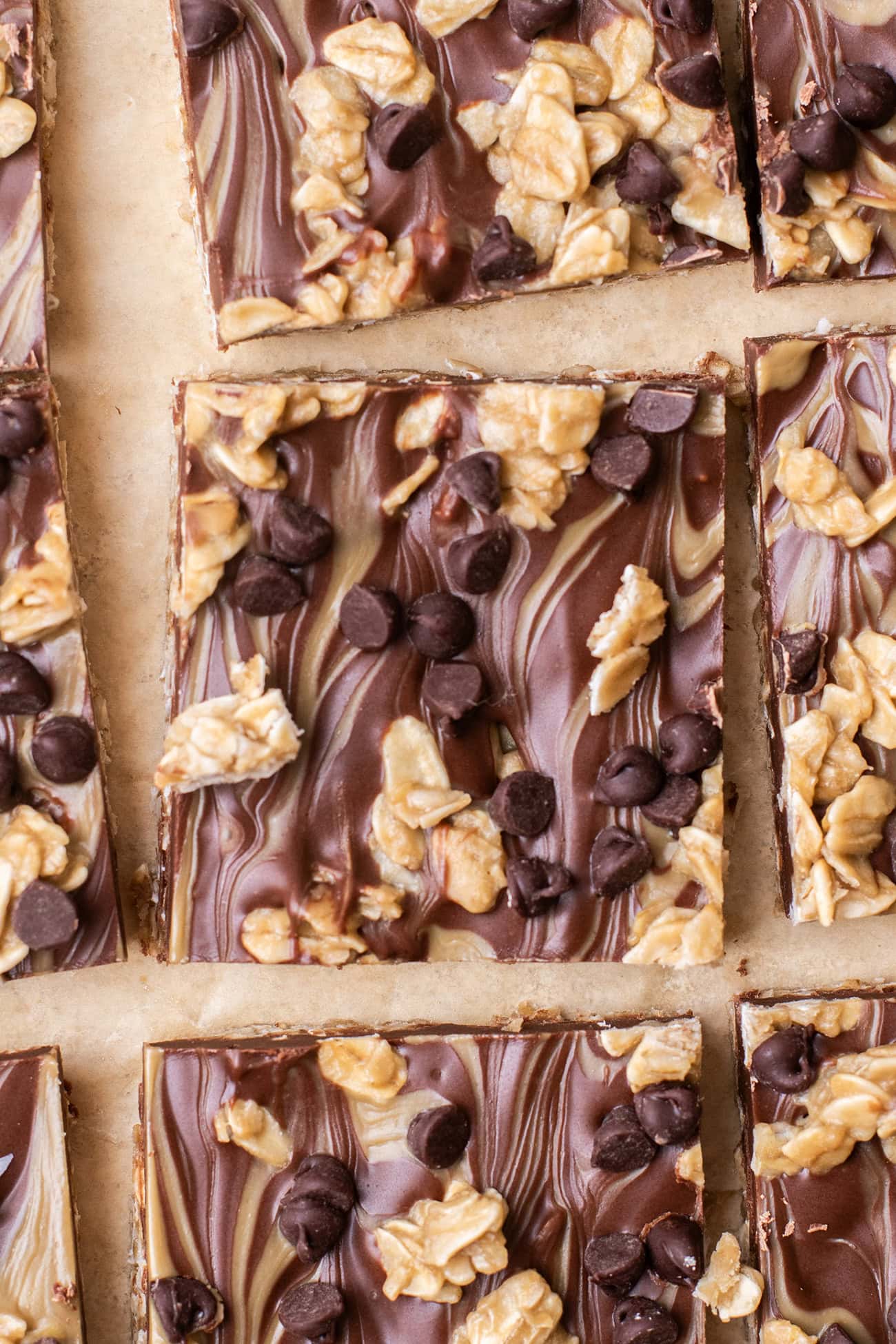 A no bake chocolate oat bar shown cut into a square on brown parchment paper.