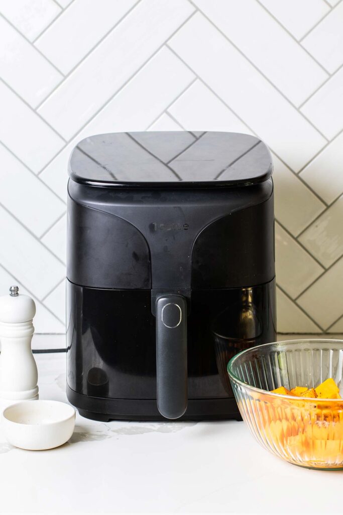 An air fryer sitting on the counter being preheated.