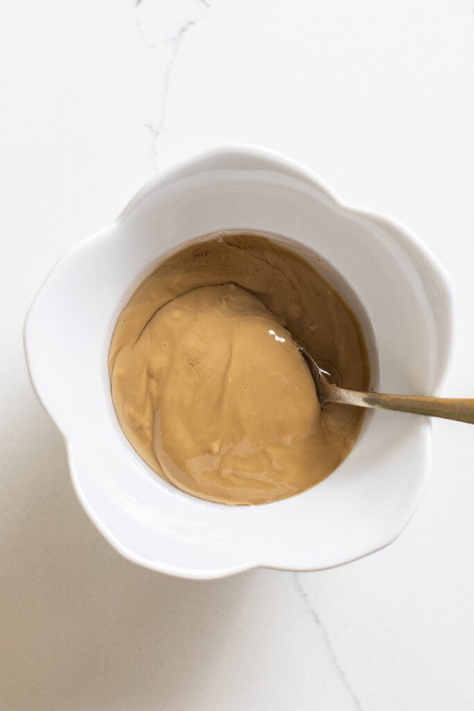 SunButter and coconut oil being combined in a small bowl.