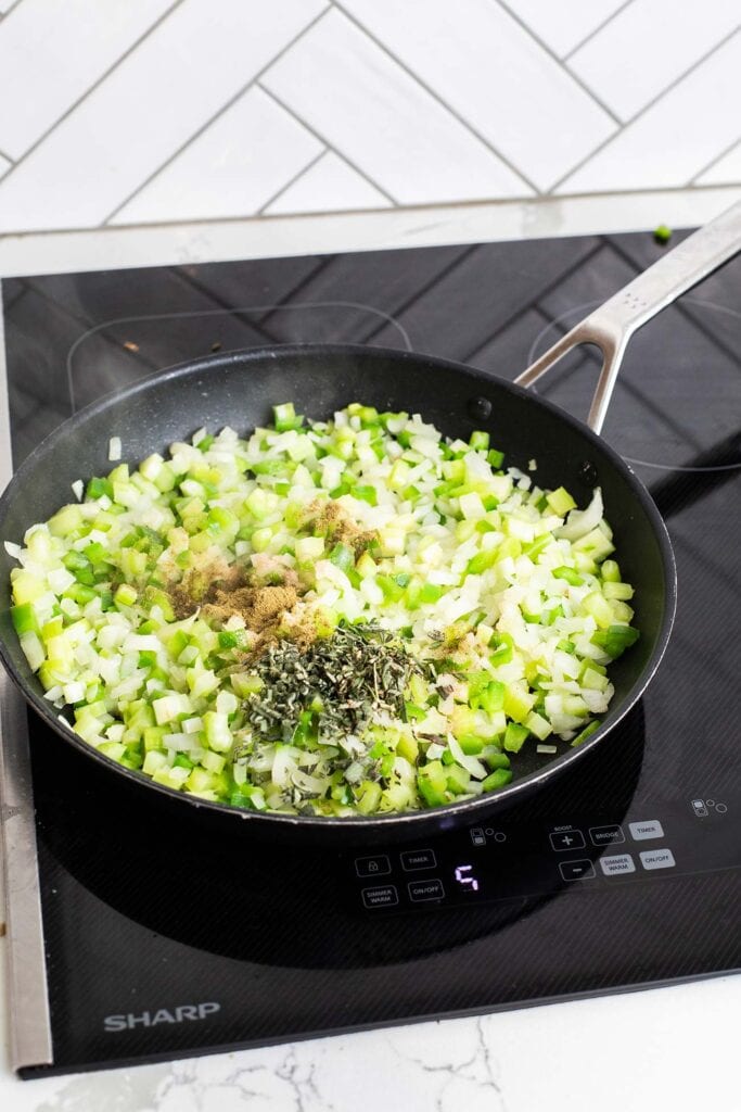 Vegetables in a skillet seasoned with herbs, salt and pepper.