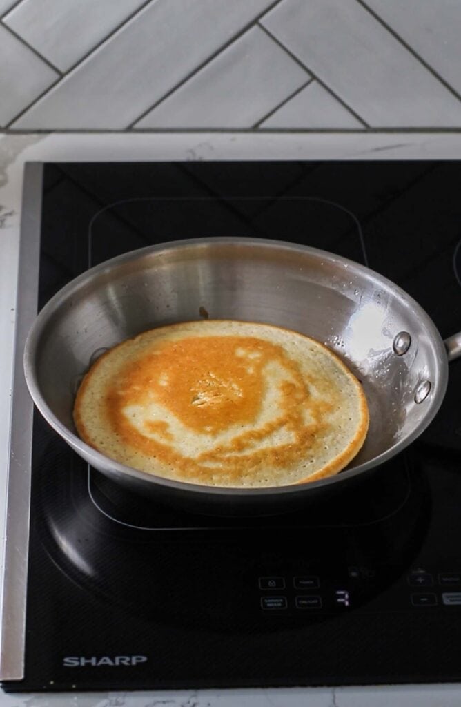 A pancake in a skillet browned.