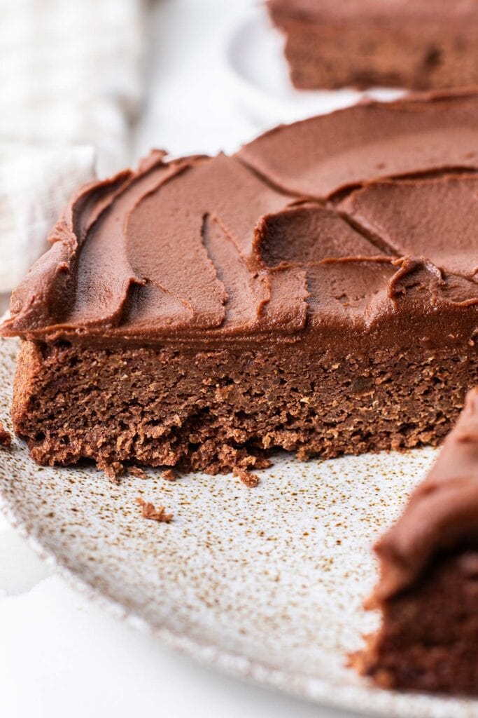 A chocolate quinoa cake cut with a slice removed.