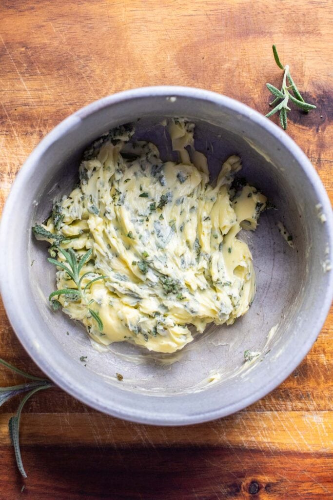 Butter and chopped herbs combined in a small bowl.