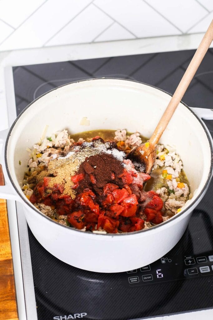 Add in the tomatoes, broth, and chili spices.