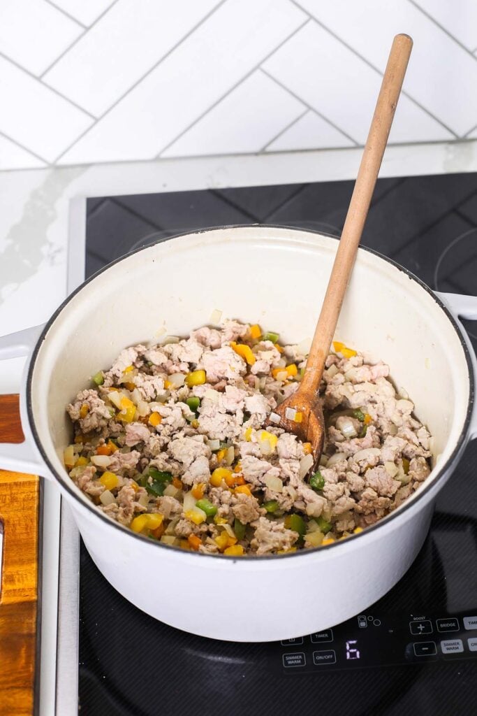 Ground turkey being browned in the pot along with the vegetables.