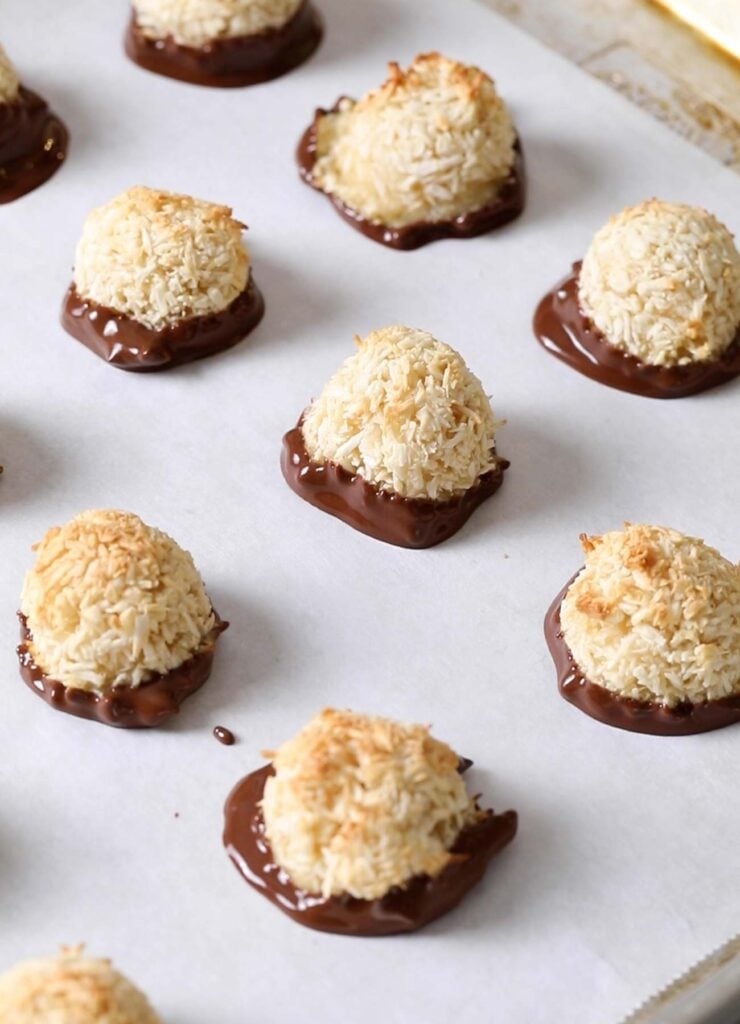 Coconut macaroon cookies shown dipped in chocolate.