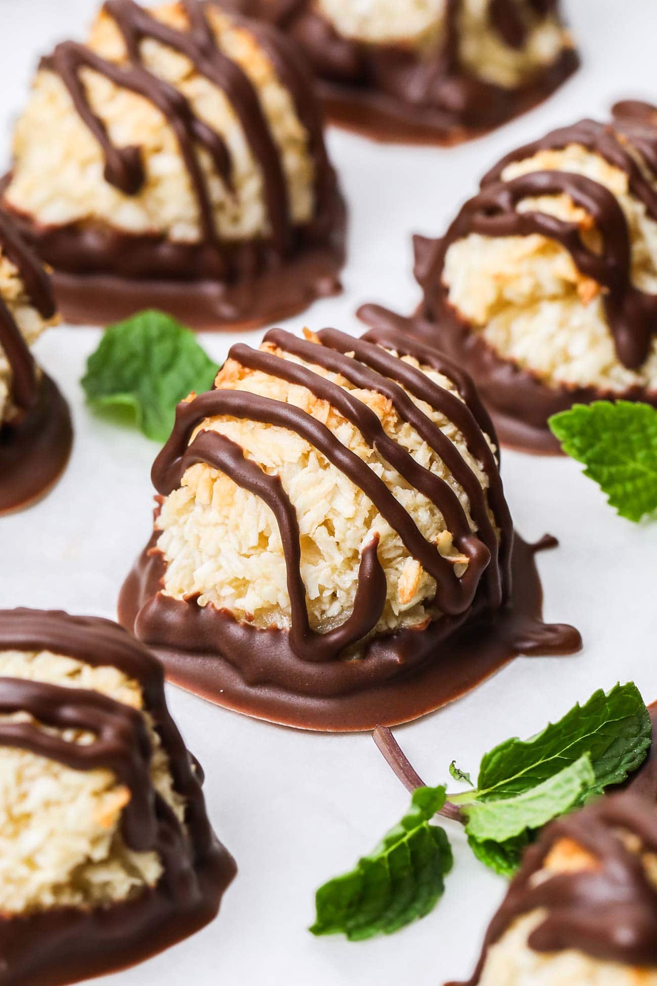 A close up shot of a macaroon cookie drizzled wtih dark chocolate.