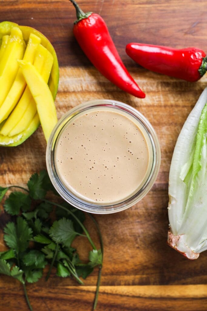 A creamy, light brown dipping sauce in a glass jar.