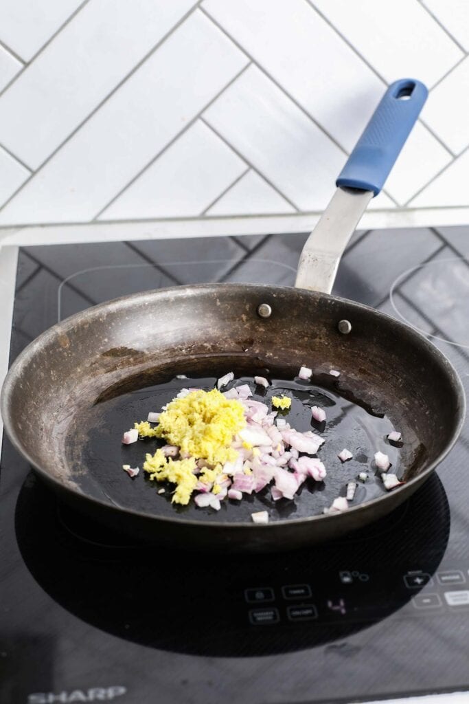 Ginger and shallots in a frying pan.