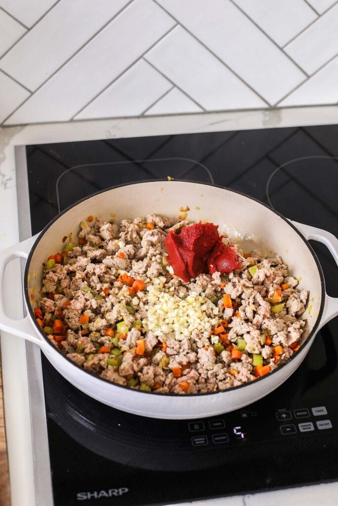 Minced garlic and tomato paste added to the pan with the turkey and vegetables.