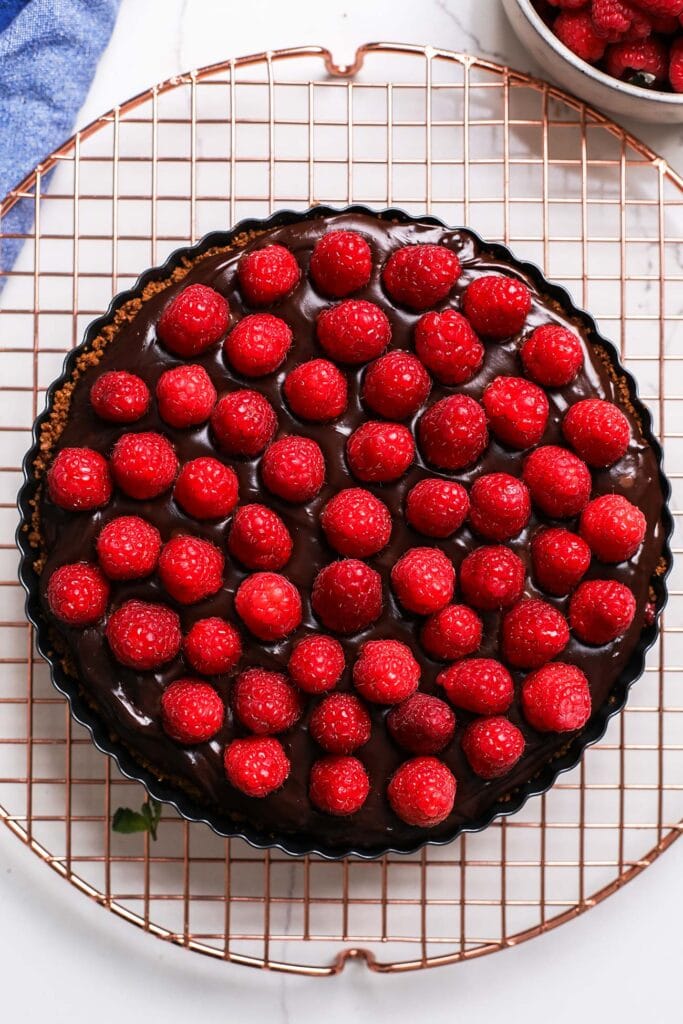 Raspberries garnishing the top of the chocolate tart.