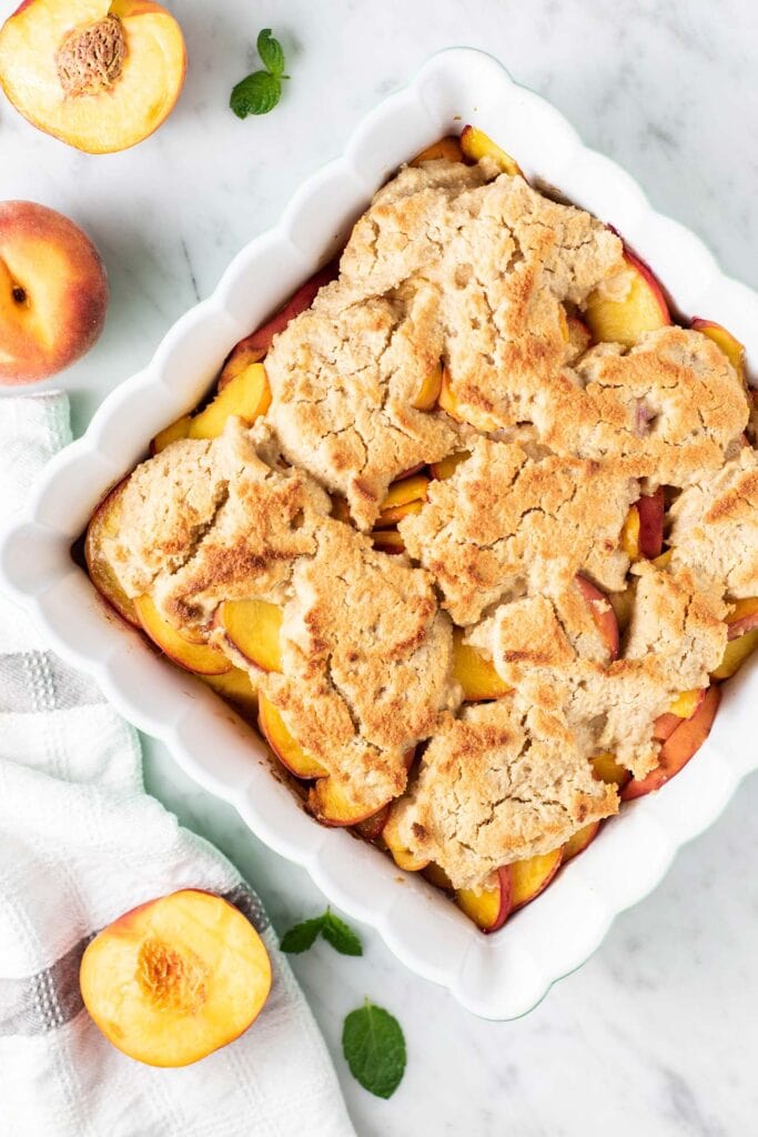 A baked peach cobbler with a golden brown top.