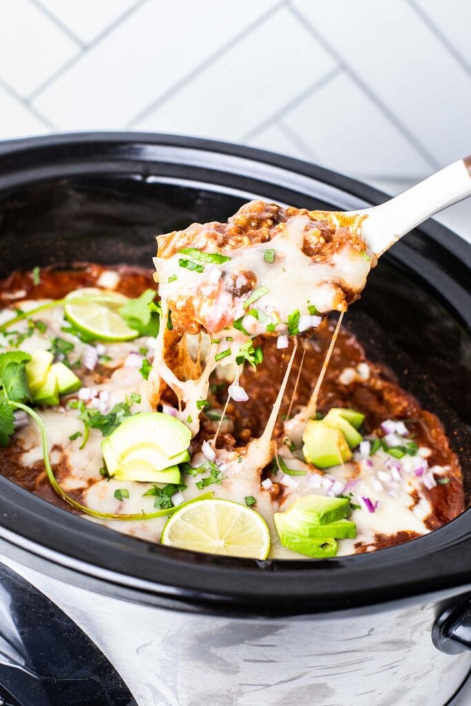 A spoon serving Mexican chicken and brown rice, with cheese pulling away from the dish.