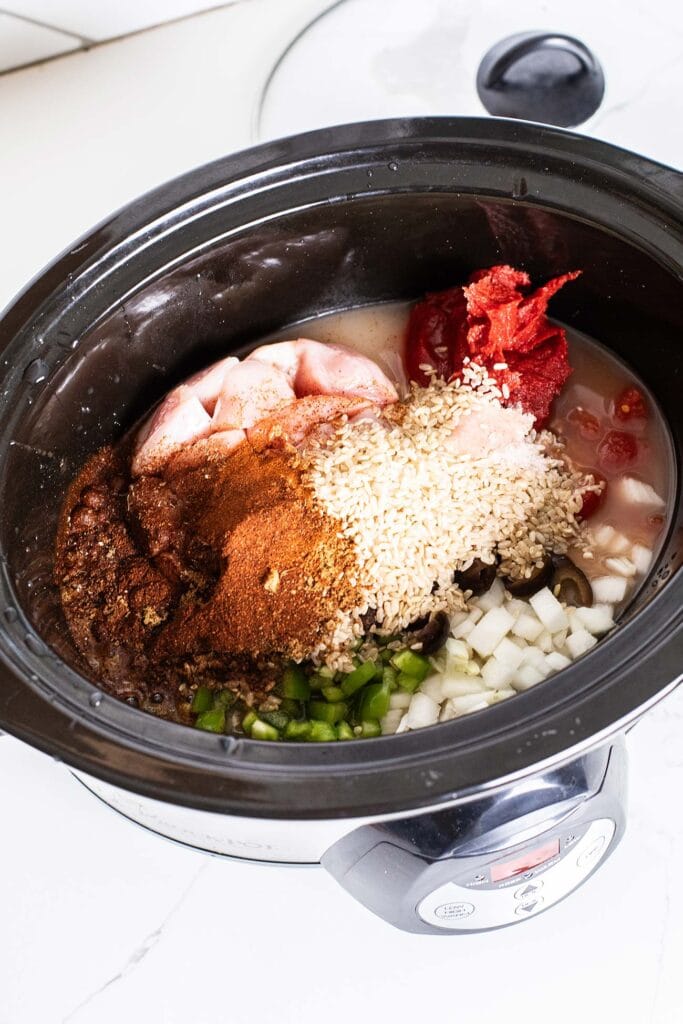 The ingredients for chicken and brown rice dumped into a crockpot.