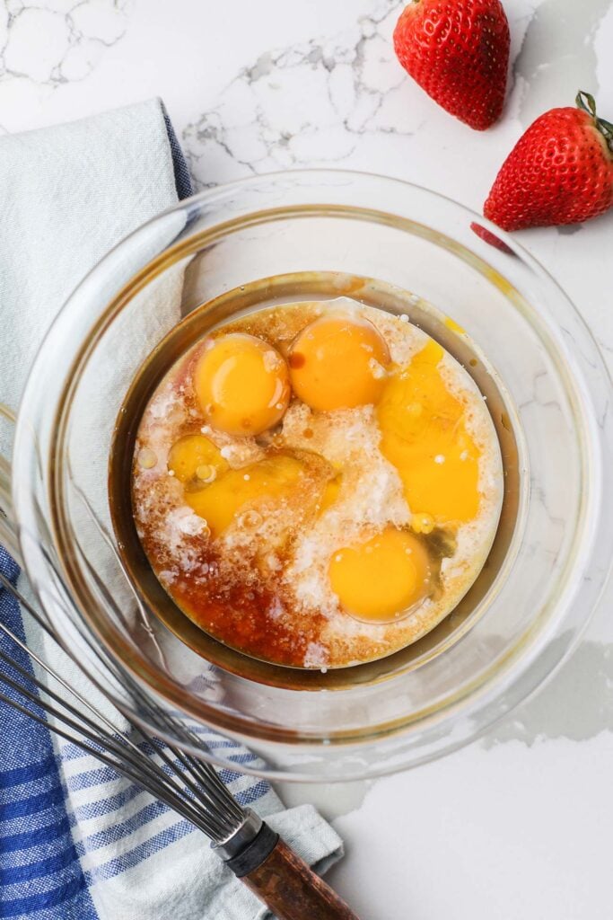 The wet ingredients combined in a bowl being whisked together.