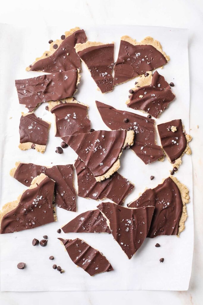 Frozen cookie dough bark being broken into smaller pieces.