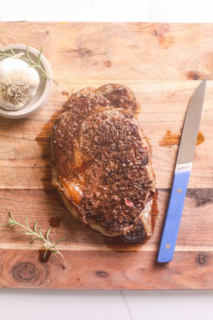 Allowing steak to rest on a cutting board prior to cutting.