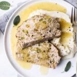 Two slices of chicken meatloaf drizzled with an apple cider gravy, over a creamy cauliflower mash.